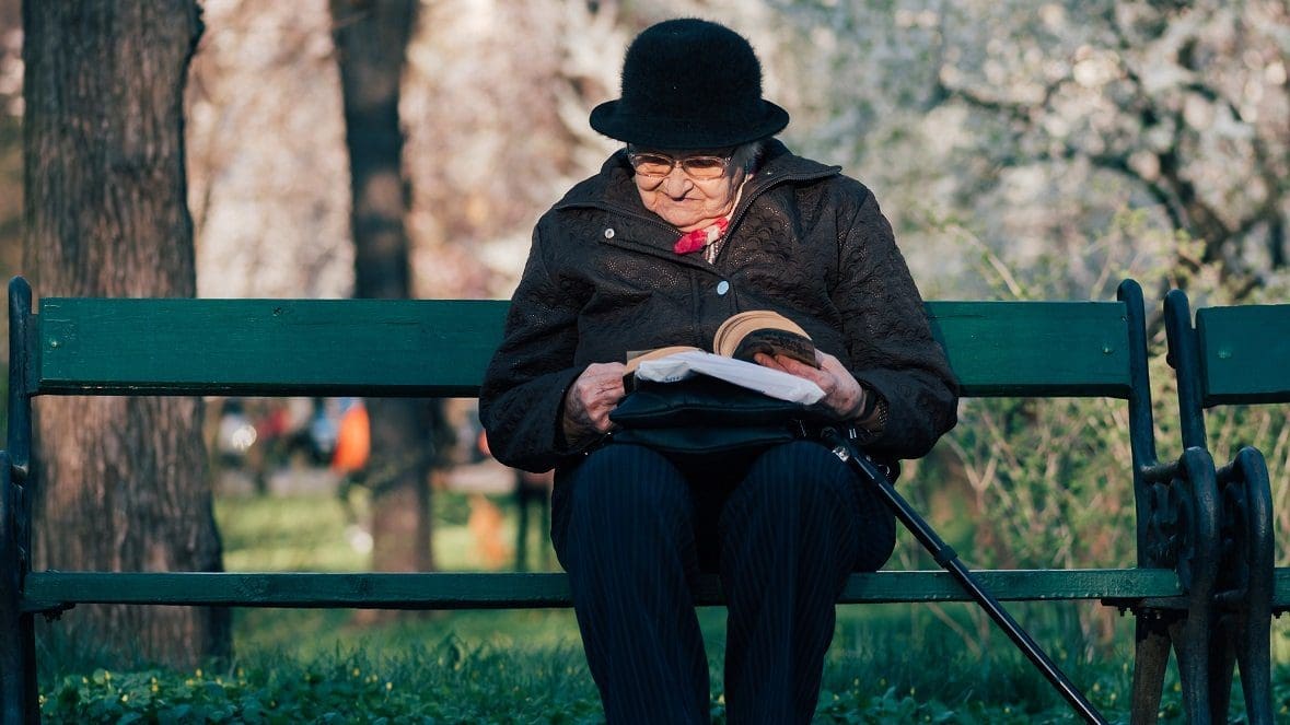 A woman sat on a bench reading a book