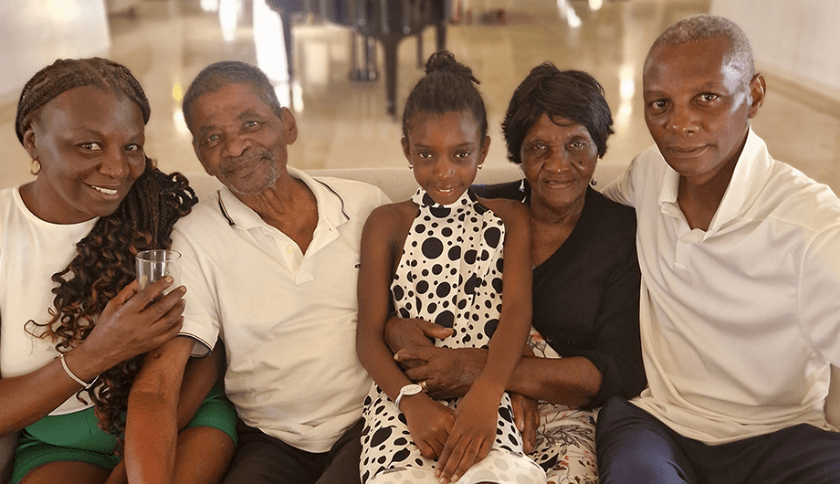 Tiana sits on the lap of Vanda and other members of their family