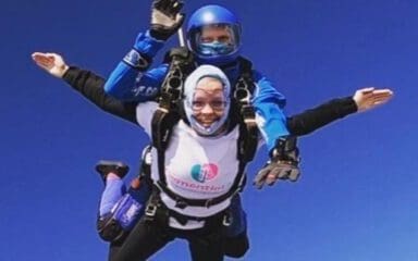 Two people skydiving while wearing Dementia UK t-shirts