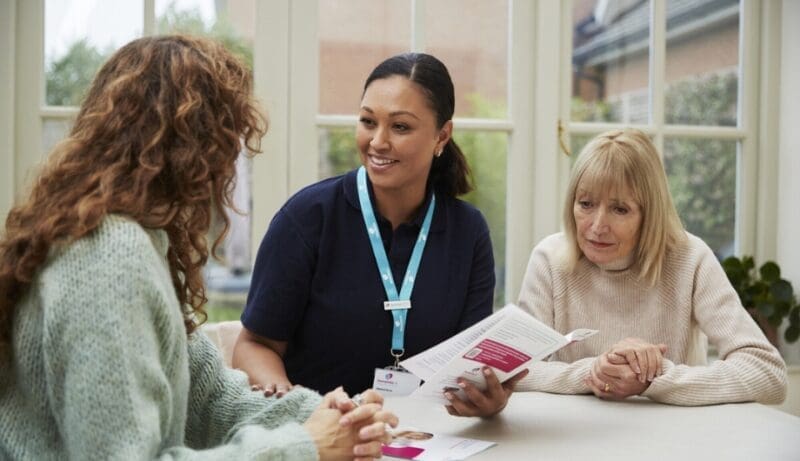 dementia specialist admiral nurse shares leaflets with a family