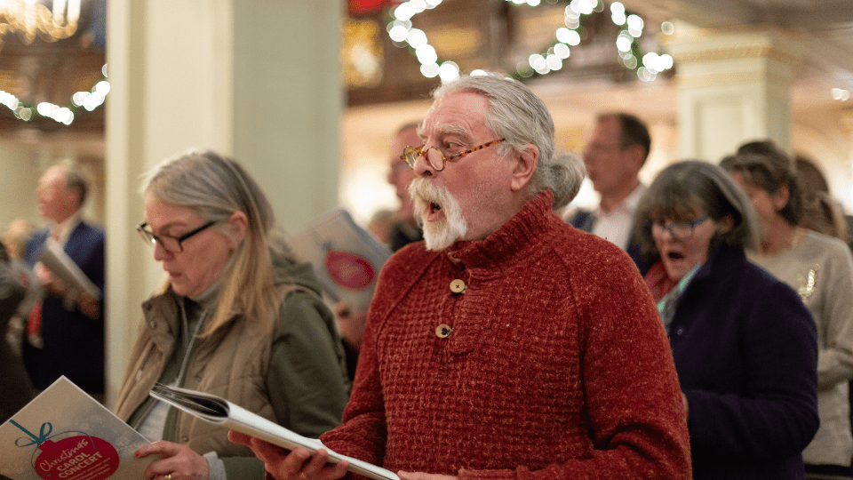 Man and wife singing carols in a church