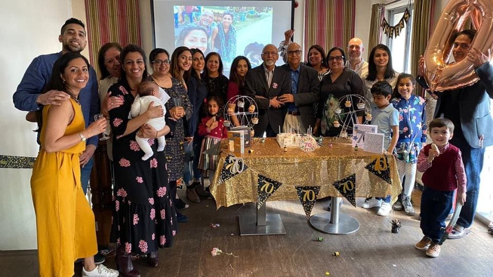 A large family group photo celebrating an Eshaa's father's 70th birthday