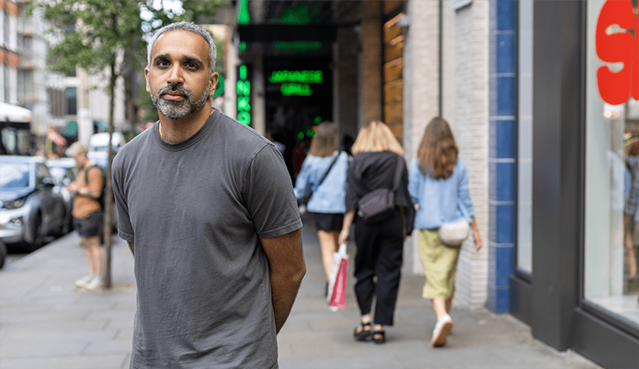 Ricky stands on a busy pedestrian street