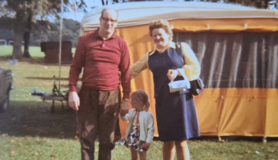 Man and woman standing next to each other with their daughter in between them who is of a small child's age