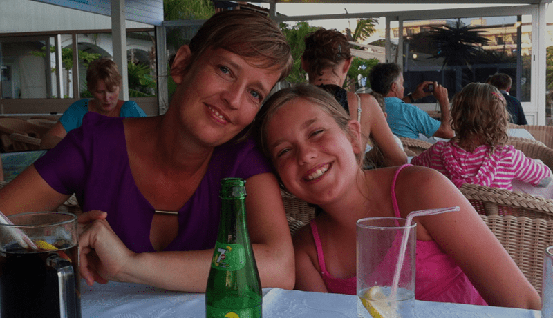 Chloe and her mum smile while at a restaurant