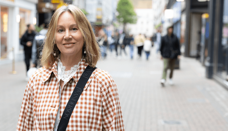 Marianne stands in a busy street