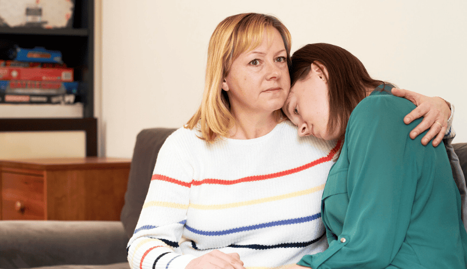 Mother, hugging daughter on the sofa