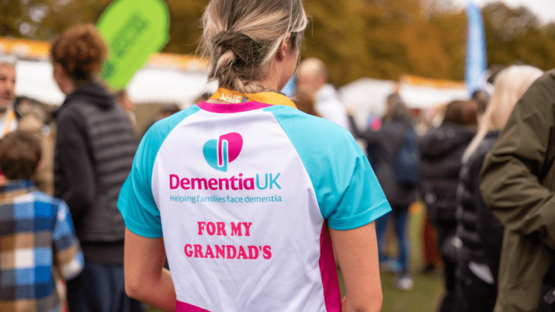 Women taking part in an event for Dementia UK. Her back to camera with 'For my Grandad's' on her t-shirt.