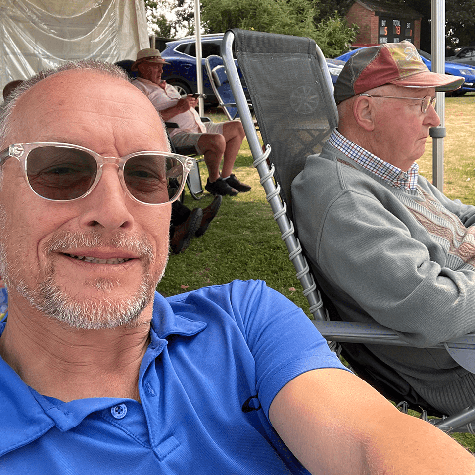 Simon sits alongside his father, Jack, at a cricket match