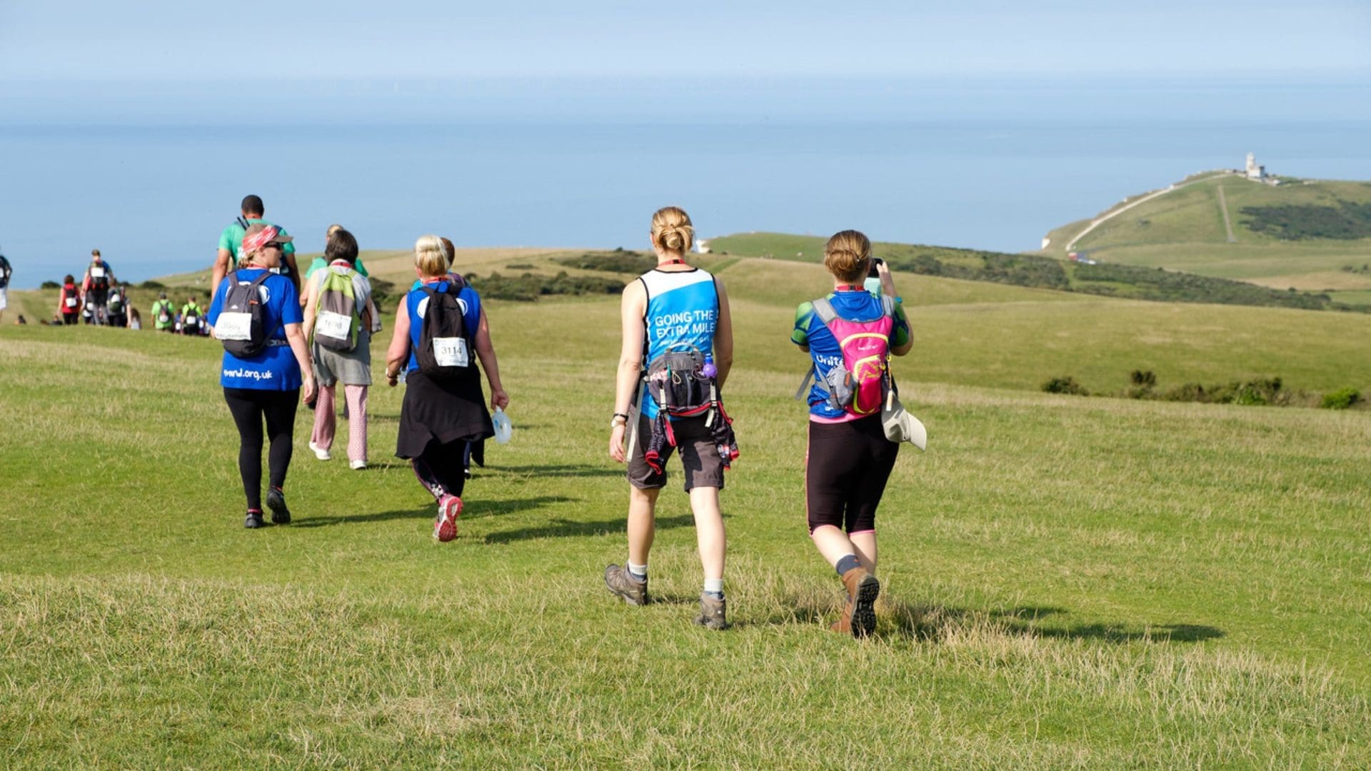 group of five people walking in nature towards the coastline