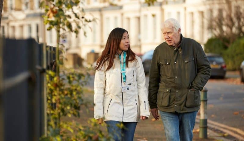 Admiral Nurse walking and talking with elderly man