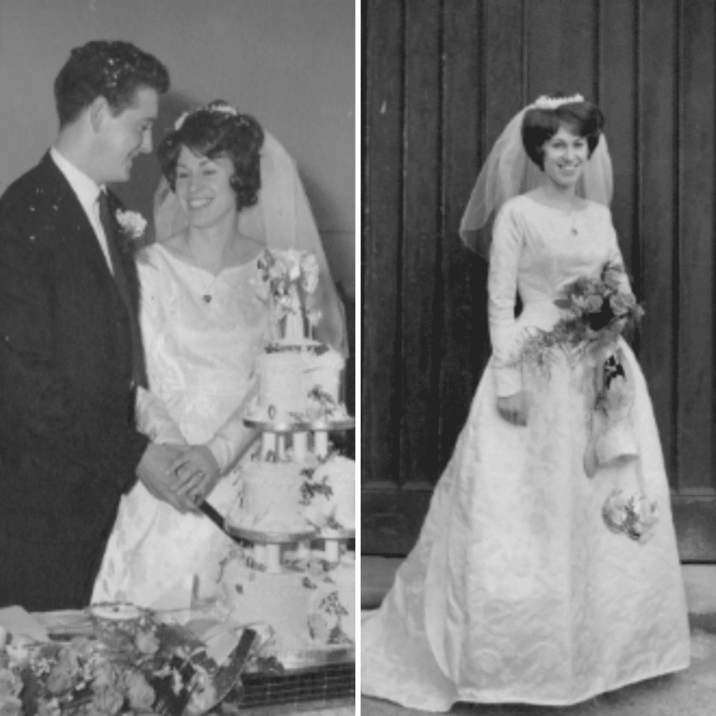 Janet and Bob cut their wedding cake. Janet in her wedding dress holding flowers.