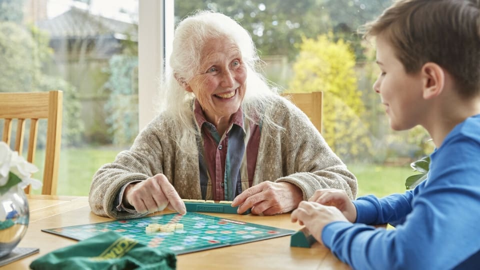 A woman playing scrabble with a child.