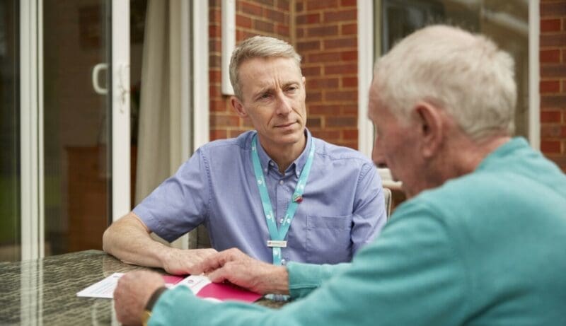 dementia specialist admiral nurse gary talks with elderly man