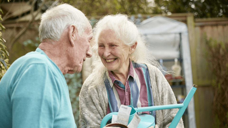 couple sitting outside in garden smiling