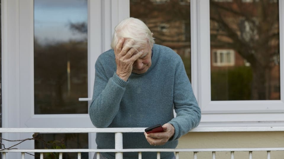 distressed elderly man texting