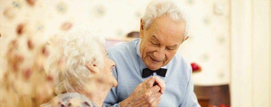 elderly couple holding hands