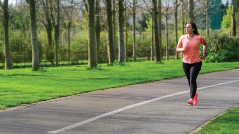 woman running along a path in a park