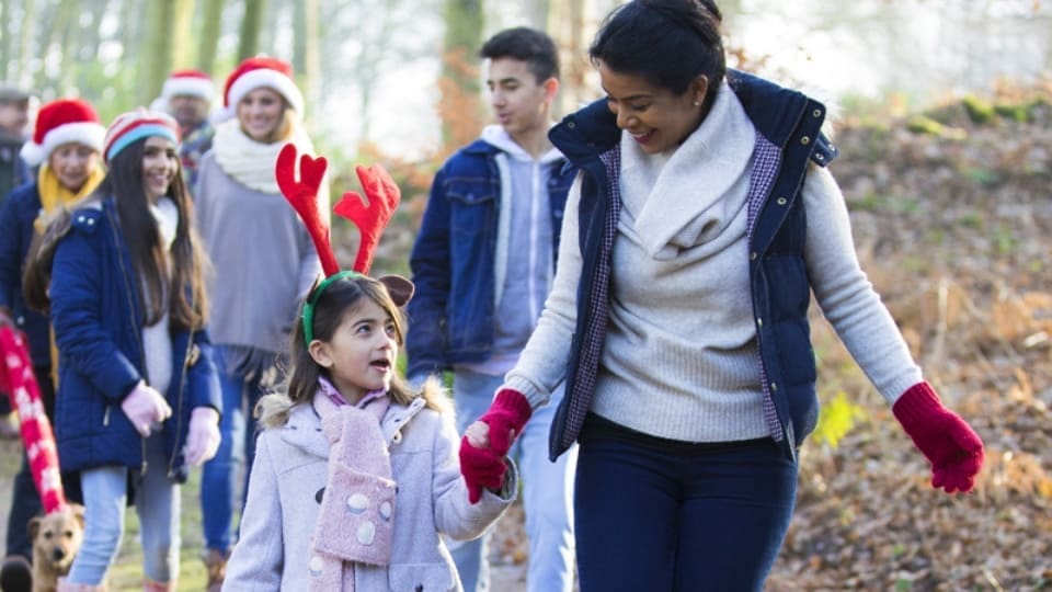 group of people wearing santa hats on a walking trail