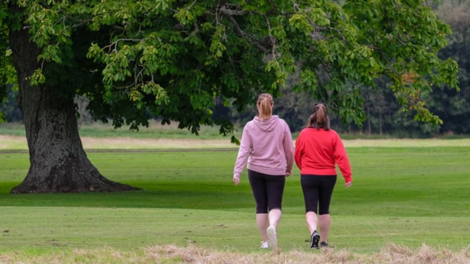 two women walking in a park