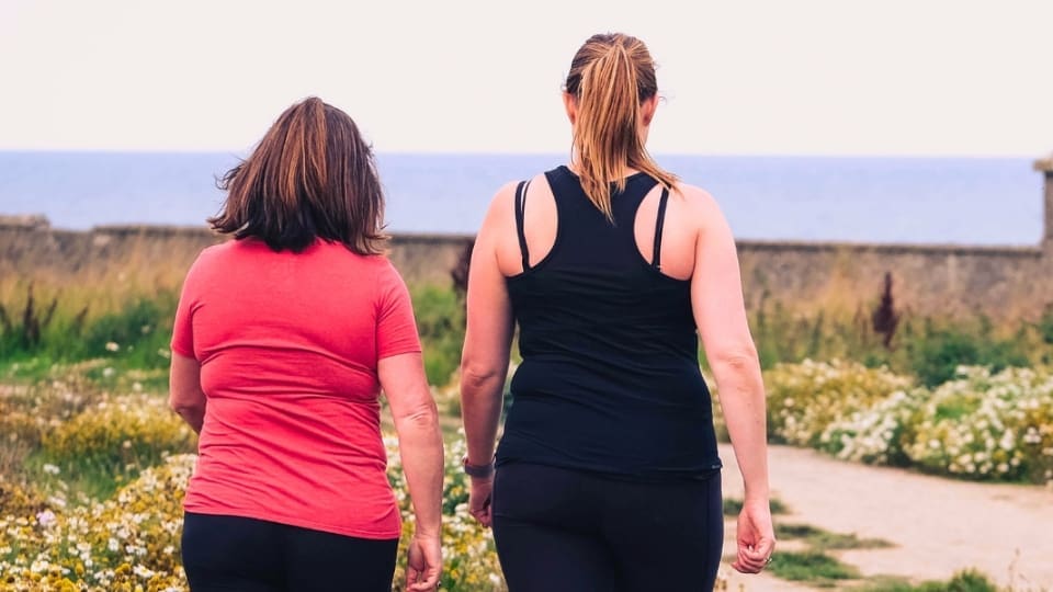 two women walking with their backs turned to us