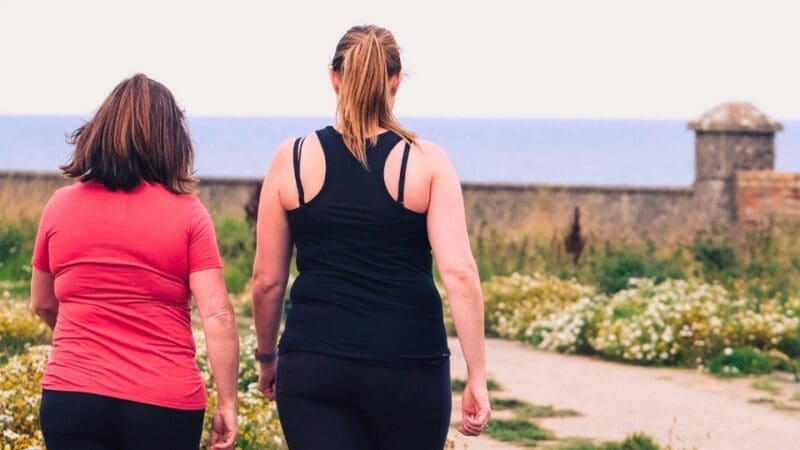 two women walking with their backs turned to us