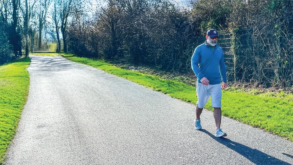 middle aged man walking down a path