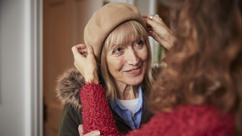 A woman gets ready to go outside on a walk.